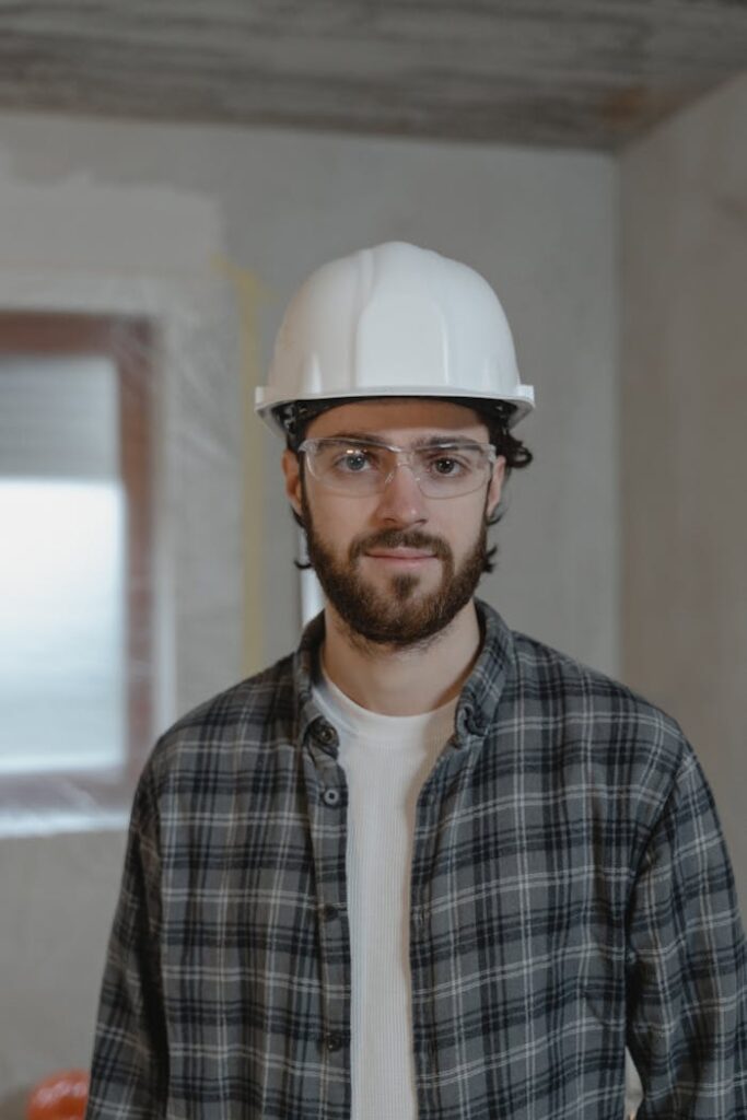 Man in Black and White Plaid Button Up Shirt Wearing White Hard Hat